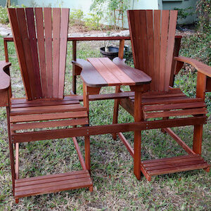 dark colored adirondack bench pictured outside on grass